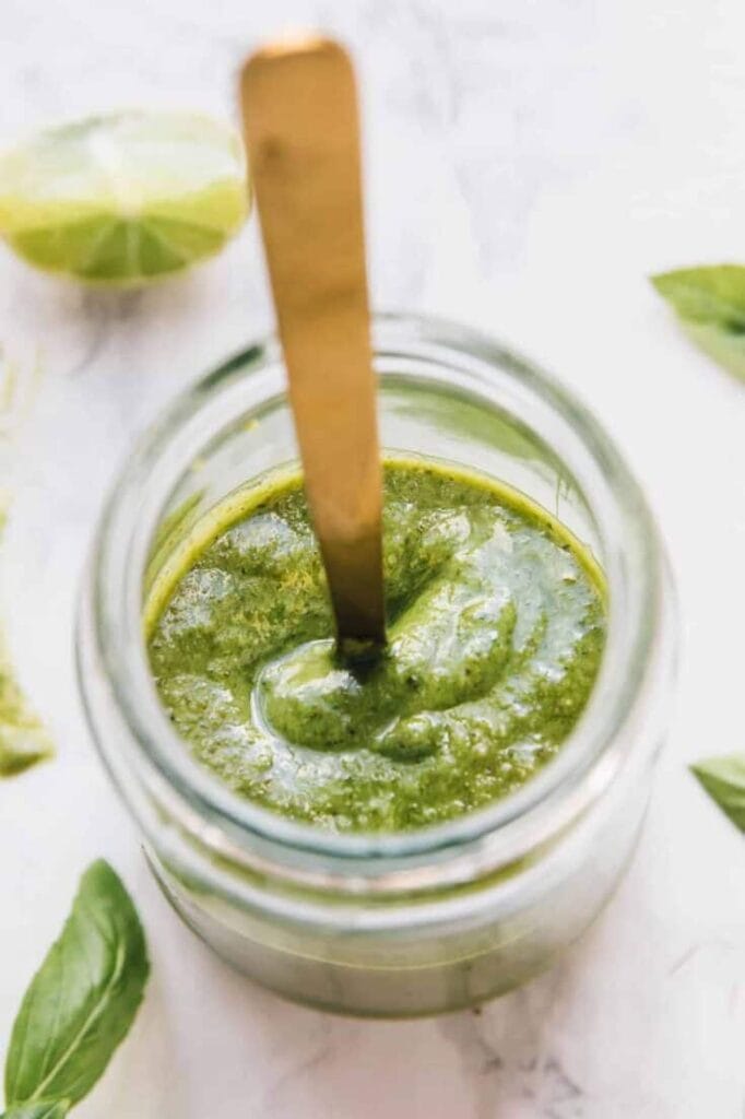 Vegan Basil Pesto with spoon in Sticking out of Jar