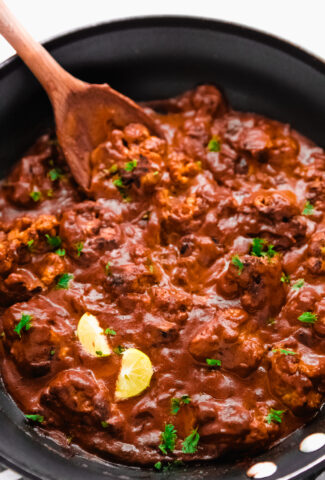 Vegan butter chicken in a pot with spoon sticking in